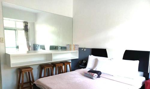 a bedroom with a bed and some chairs and a window at Beach condos at Pico de Loro Cove - Wi-Fi & Netflix, 42-50''TVs with Cignal cable, Uratex beds & pillows, equipped kitchen, balcony, parking - guest registration fee is not included in Nasugbu