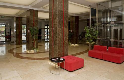 オストラヴァにあるMini Hotel Akordの赤いソファとテーブルのあるロビー