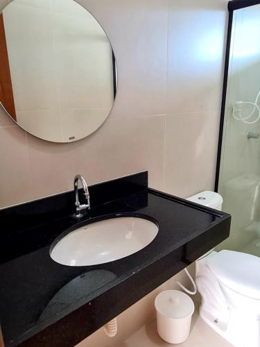 a bathroom with a sink and a mirror and a toilet at Casa 17 Lençóis Maranhenses - Barreirinhas - MA in Barreirinhas