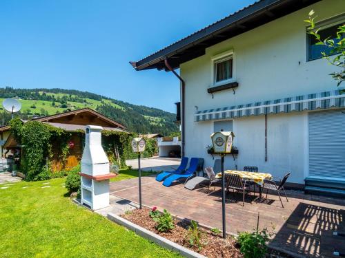 a backyard with a table and chairs and a house at Apartment in Tirol with private garden in Kirchberg in Tirol