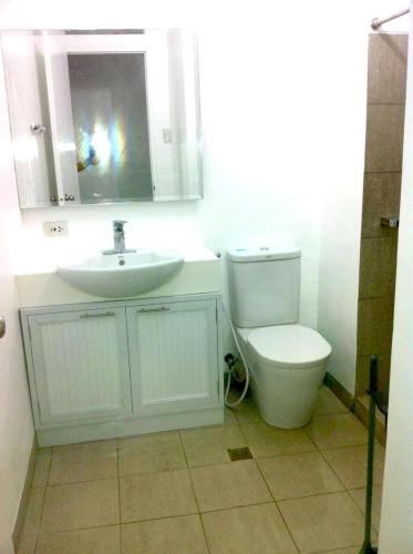 a bathroom with a sink and a toilet and a mirror at Beach condos at Pico de Loro Cove - Wi-Fi & Netflix, 42-50''TVs with Cignal cable, Uratex beds & pillows, equipped kitchen, balcony, parking - guest registration fee is not included in Nasugbu