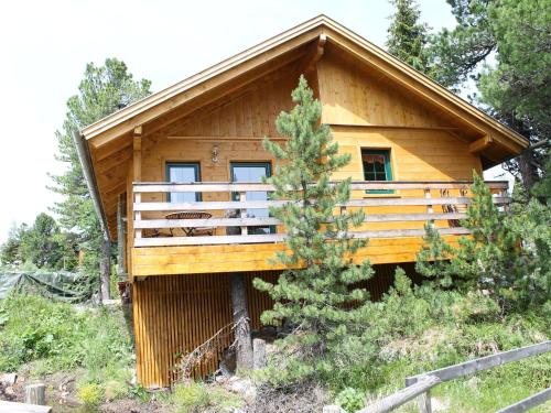 a log cabin with a balcony in the woods at Spacious Chalet near Ski Area in Turracherhohe in Turracher Hohe