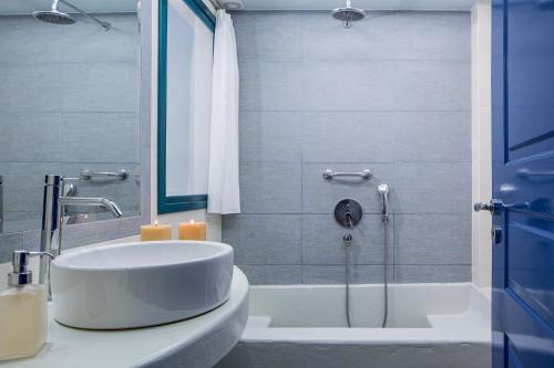 a bathroom with a shower, sink, and tub at Veggera Beach Hotel in Perissa
