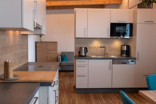 uma cozinha com armários brancos e um lavatório em Mountain Lodge em Galtür