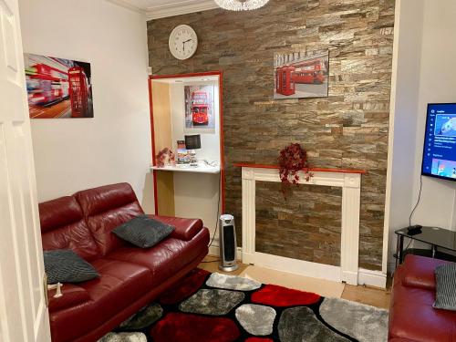 a living room with a couch and a stone wall at SureScape House in Liverpool