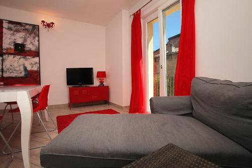 a living room with a couch and red curtains at Villa Maggie on Lake Como in Malgrate