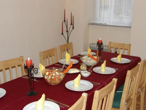 a dining room table with red candles on it at Pension am Elberadweg in Radebeul