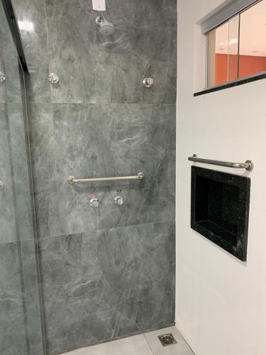 baño con ducha y puerta de cristal en Pousada Piri Paim, en Pirenópolis