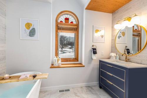 a bathroom with a tub and a sink and a mirror at Peaceful 2-bedroom townhome retreat w/wooded view in Galena