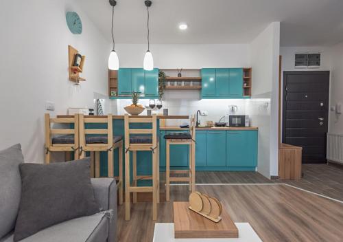 a kitchen with blue cabinets and a living room with a couch at Apartman Kesten - Апартман Кестен in Banja Koviljača