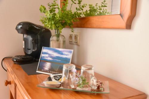 a table with a tray with glasses and a laptop on it at HOTEL MAREA in Poio