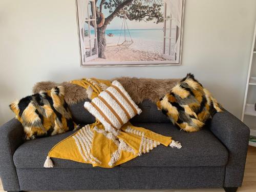 a couch with pillows and a blanket on it at Oneroa Bay Villa Waiheke in Oneroa