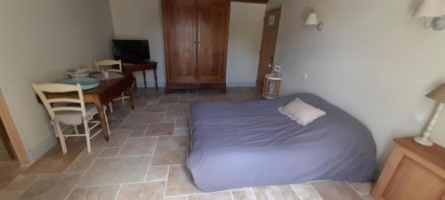 une chambre avec un lit, une table et un bureau dans l'établissement Suite de charme dans une maison charentaise, à Cozes