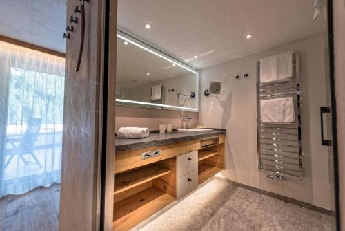 a bathroom with a sink and a mirror at Alpinhotel Berghaus spa in Tux