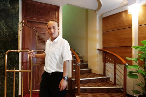 a man standing next to a set of stairs at Hotel Sentosa in Kuala Belait