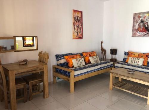 a living room with a couch and a table at Maison Aziz - Somone - Sénégal in Somone