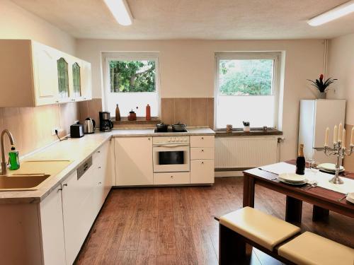 a kitchen with white appliances and wooden floors and windows at Ferienwohnung Kathlower Mühle in Neuhausen