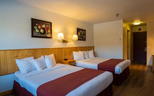 ein Hotelzimmer mit 2 Betten und 2 Lampen in der Unterkunft Canadas Best Value Inn- Riverview Hotel in Whitehorse