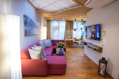 a living room with a purple couch and a table at Apartments Chalet Wirz Travel in Sarnen
