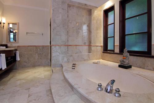 a large bathroom with a tub and a sink at Villa Surya in Tanah Lot