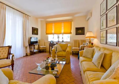 uma sala de estar com mobiliário amarelo e cortinas amarelas em VILLA MIMOSA Taormina Rooftop Terrace em Taormina