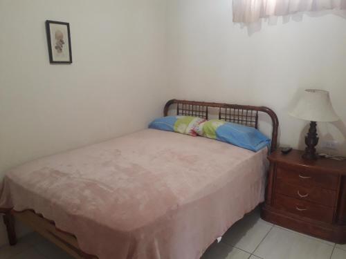 a bedroom with a bed and a dresser with a lamp at Hospedaje Maluli Suit 5 in Santa Elena