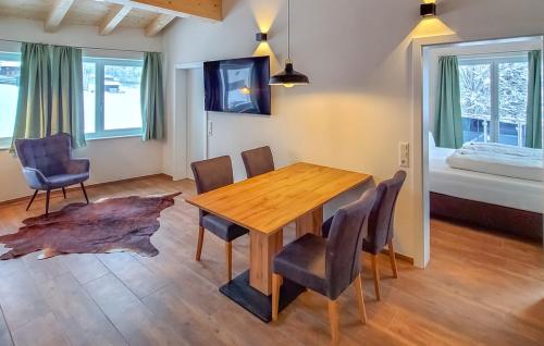 a room with a wooden table and chairs and a bed at Arlbergschmiede in Wald am Arlberg