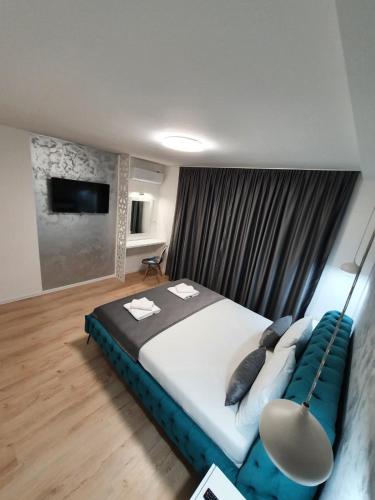 a bedroom with a large bed with a blue couch at Apartment Nedim in Mostar