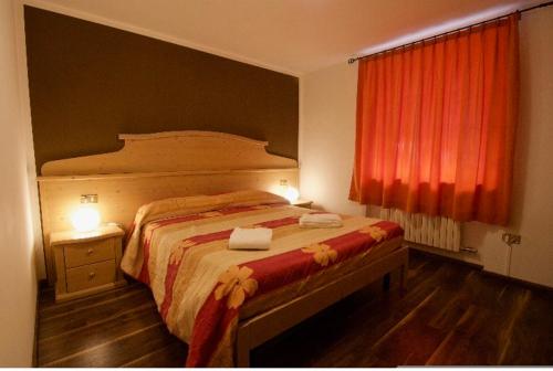 維爾米利歐的住宿－Appartamento Silvia，一间卧室配有一张带红色窗帘的大床