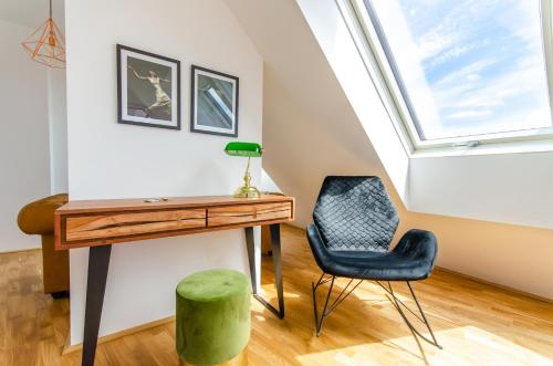 a desk and a chair in a room with a window at Grand Quarters City Residence in Vienna