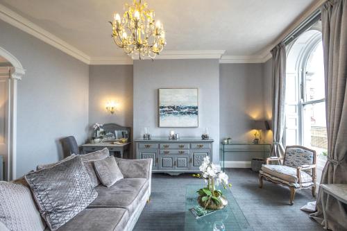 uma sala de estar com um sofá e um lustre em Gloucester House em Weymouth