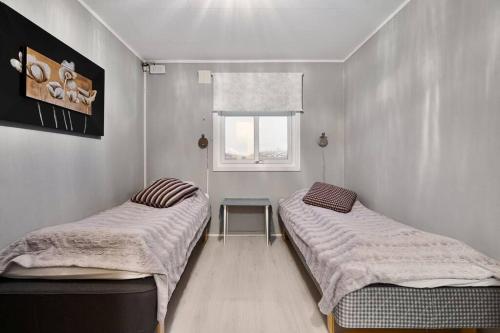 2 Einzelbetten in einem Zimmer mit Fenster in der Unterkunft Lyngen View House in Koppangen