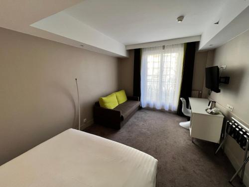a hotel room with a bed and a couch at Holiday Inn Paris-Auteuil by IHG in Paris