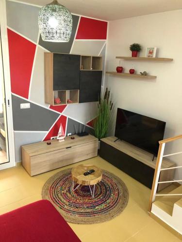 a living room with a table and a television at Charming Beach Villa Porto Santo in Porto Santo