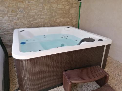 eine Whirlpool-Badewanne in einem Zimmer mit Hocker in der Unterkunft Ti ker 2 SPA in Plourin