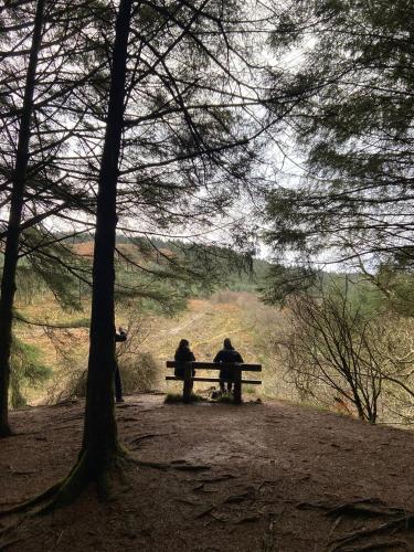 two people sitting on a bench in a park at Wee Silverburn in Whiting Bay