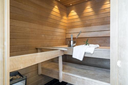 a sauna with wooden walls and a white towel at Hiisi Hotel Helsinki Jätkäsaari in Helsinki