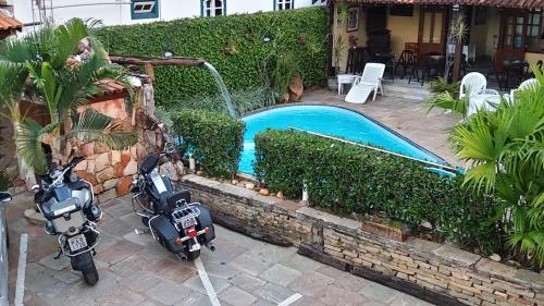 two motorcycles parked next to a small swimming pool at Pousada do Abacateiro in Pirenópolis