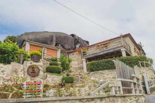 a house with a large tree on top of it at Casa do Penedo in Viana do Castelo