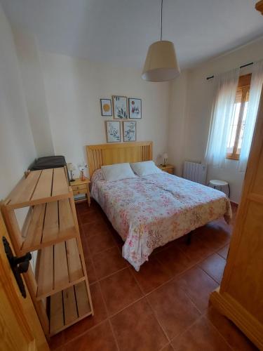 een slaapkamer met een bed en een houten ladder bij Apartamento Huerta Grande in Benaocaz