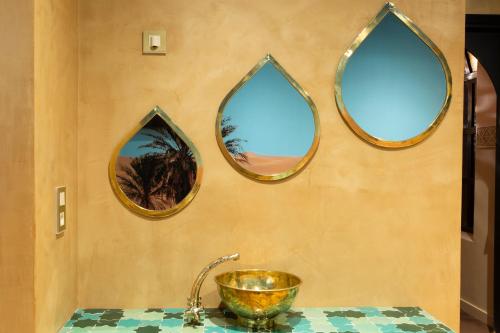 a bathroom with three mirrors on a wall with a sink at Kechmara hammam&spa in Lille