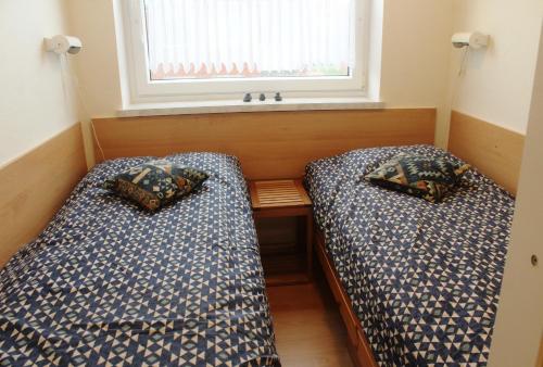 Duas camas num pequeno quarto com uma janela em Fewo 91 WHG B 12 in Burhave em Burhave