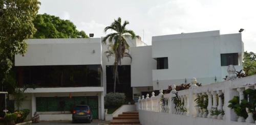 a car parked in front of a white building at Habitaciones Familiares Hacienda Botero in Turbaco