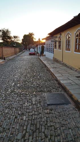 a cobblestone street with a car parked on it at Pousada do Abacateiro in Pirenópolis