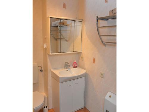 uma casa de banho com um lavatório, um WC e um espelho. em Fewo 91 WHG B 12 in Burhave em Burhave