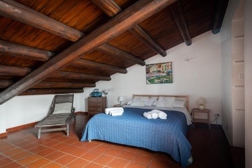 um quarto com uma cama e uma cadeira e tectos em madeira em Attico Sesto Canto em Palermo