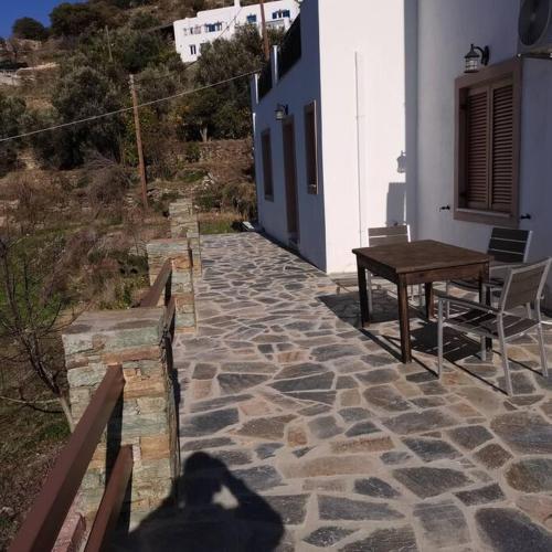 a stone walkway with a wooden table on a building at Melissa Houses in Apróvaton