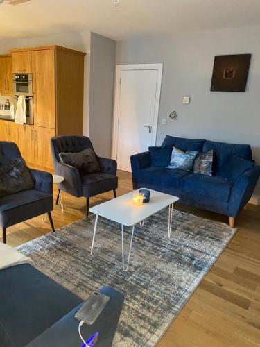 sala de estar con sofá azul y mesa en The moorings, en Belmullet