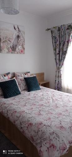 a bedroom with a bed with a horse picture on the wall at La Casa Alana in Vişeu de Jos