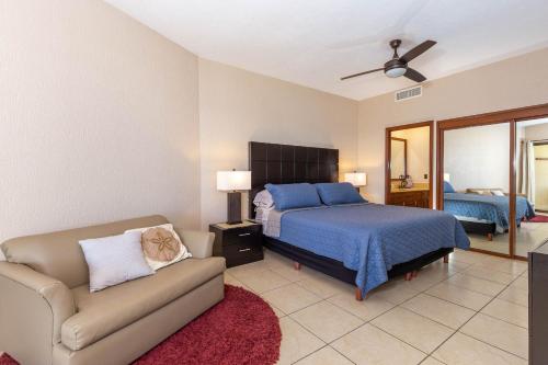 a bedroom with a bed and a couch at Sonoran Sun Ground Floor - 104-W in Puerto Peñasco